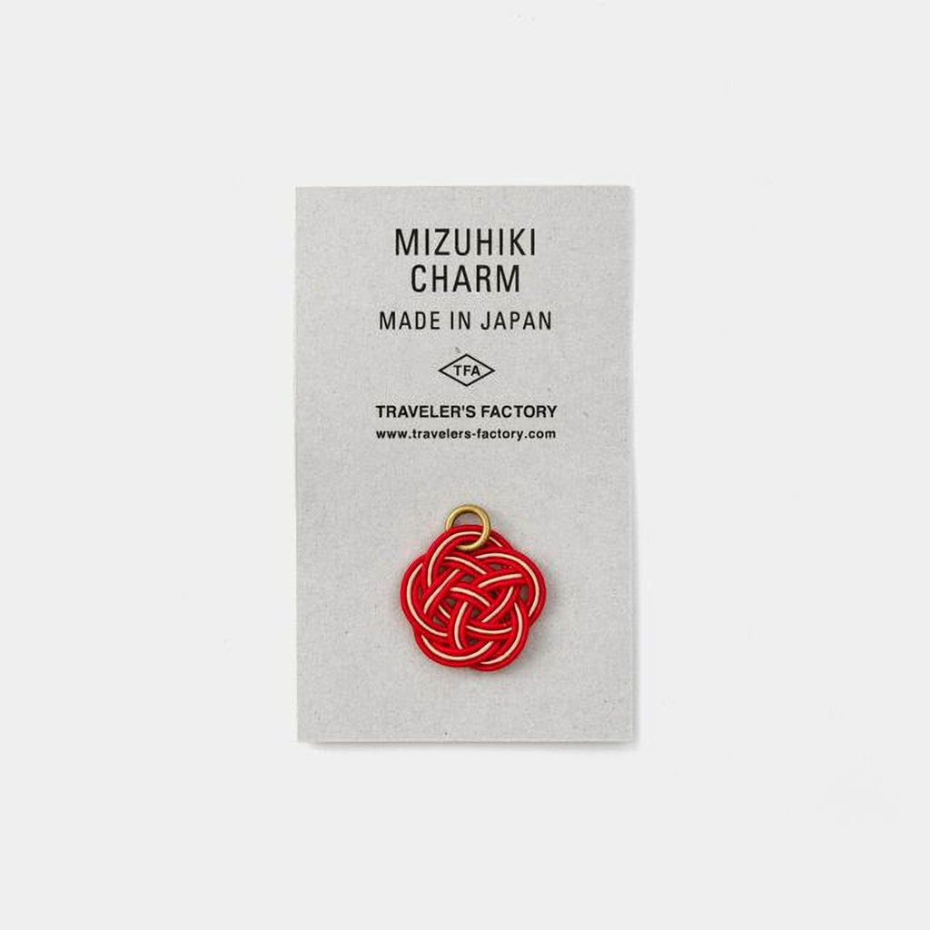 a charm made in Japan, with a red knot design, displayed on a white background.