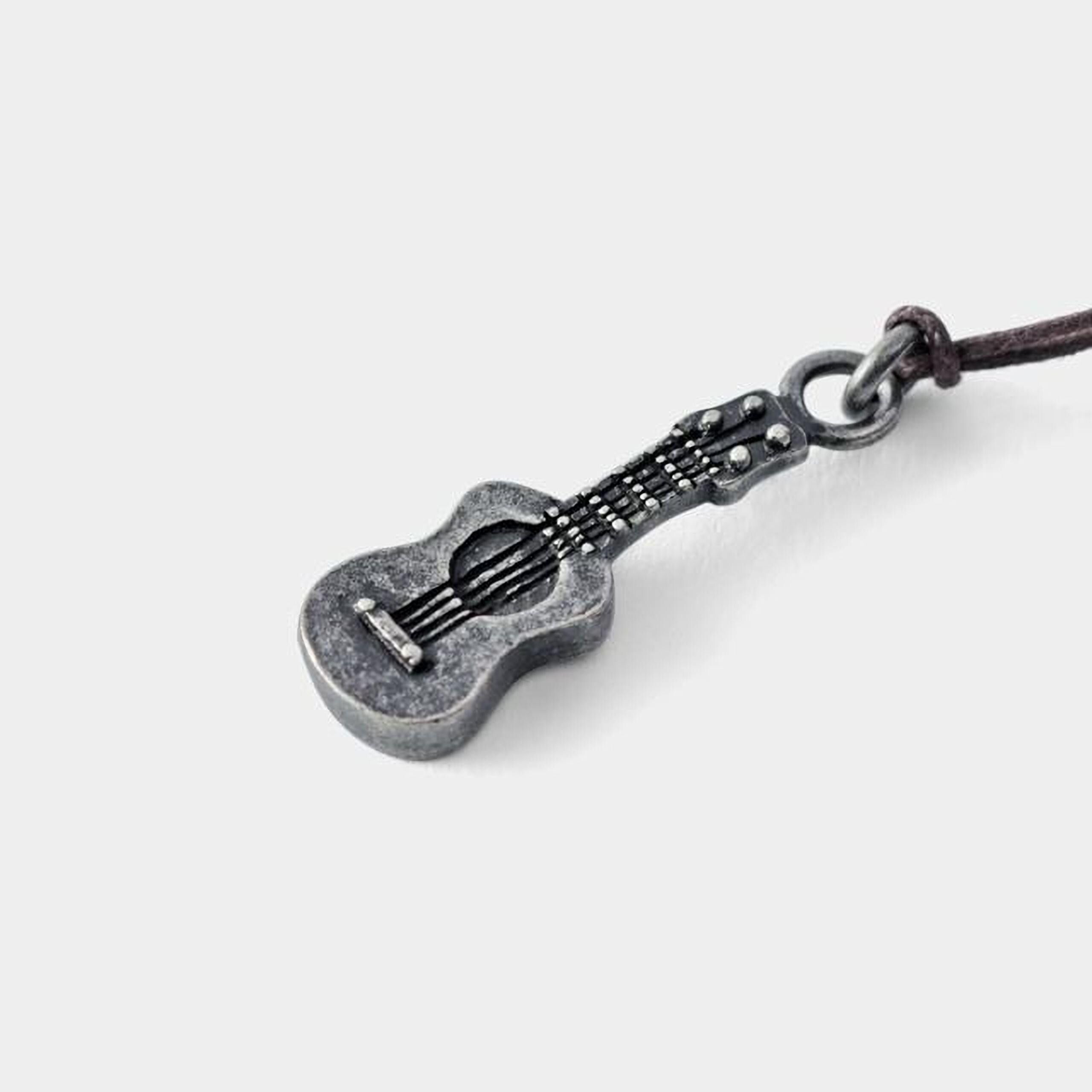 A silver-colored pendant in the shape of a guitar is shown against a plain white background.