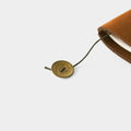 a brown leather-bound notebook with a gold-colored metal clasp attached to the top edge.