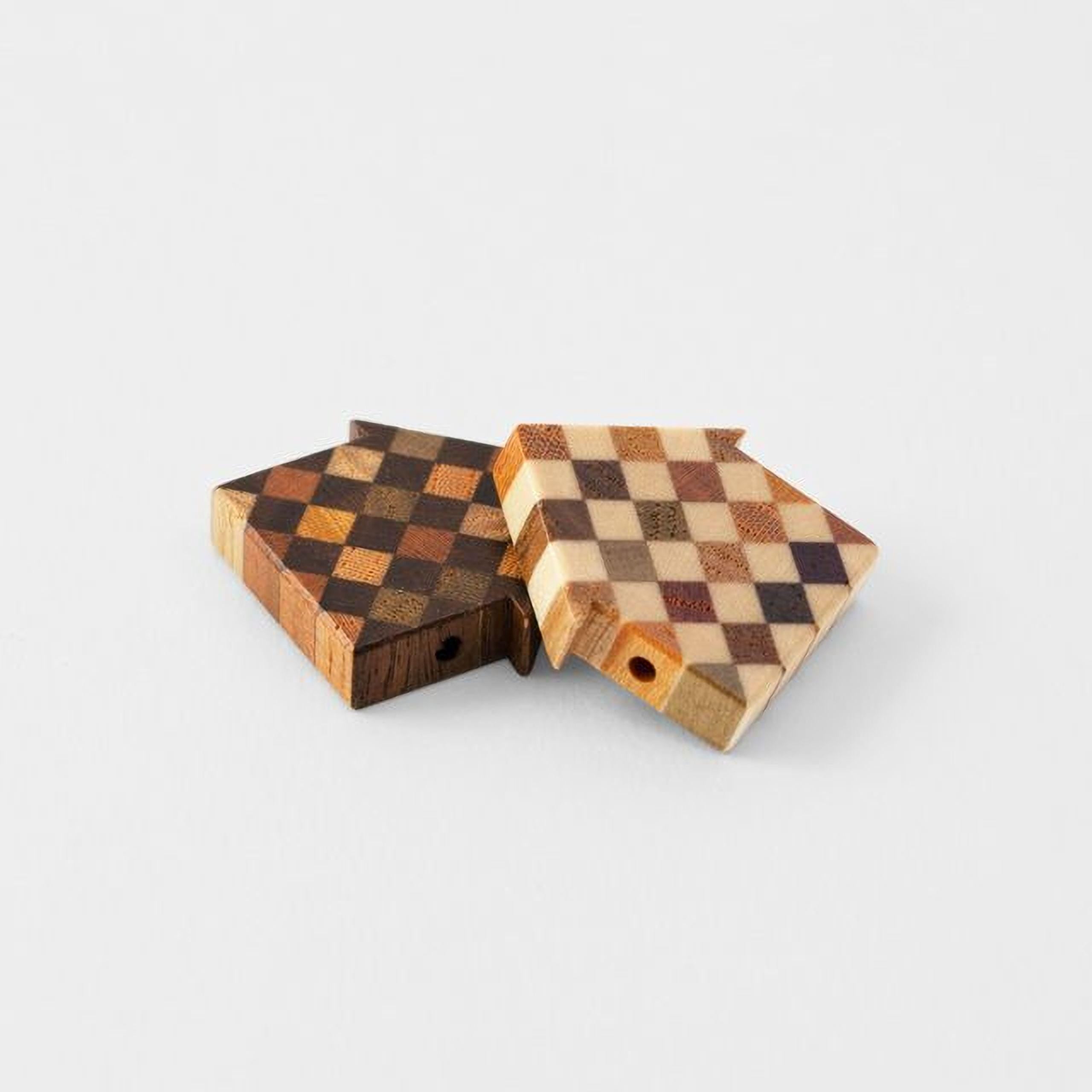 Two wooden blocks with a checkered pattern are placed on a white background.