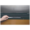 A hand is holding a small object, possibly a tool, and placing it on a black surface.