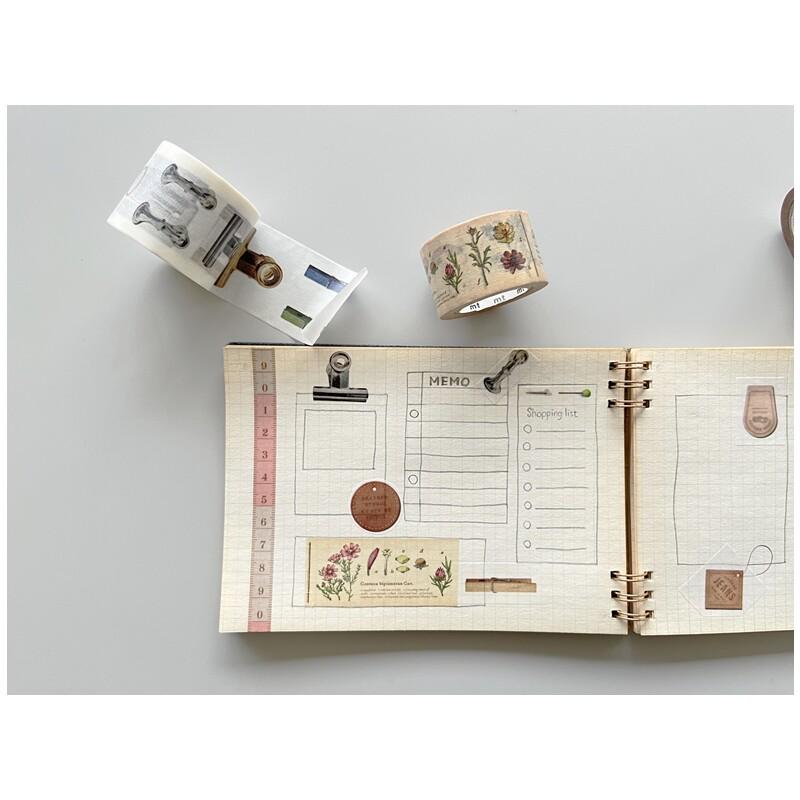 a notebook with a list of items, a roll of tape, and a stapler on a white surface.