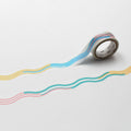 A roll of colorful tape with a wavy pattern is lying on a white surface.