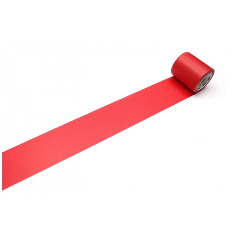 A roll of red tape is lying on a white surface, with the tape unspooled and extending across the image.