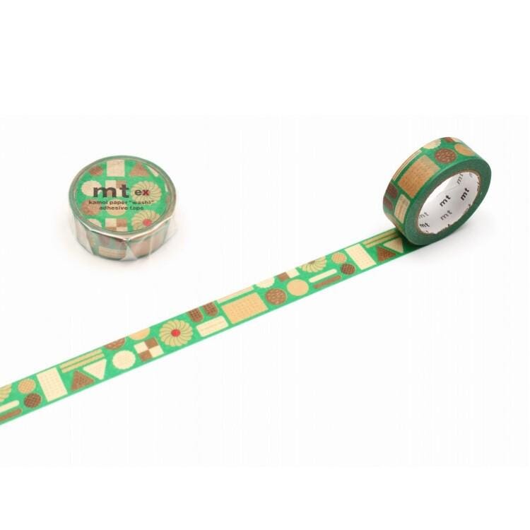 a roll of green and brown patterned tape with a geometric design, lying on a white surface.