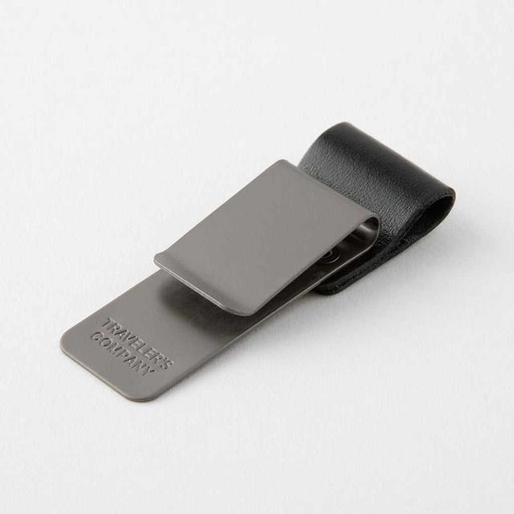 A gray metal clip with a black leather loop attached to it, resting on a white background.