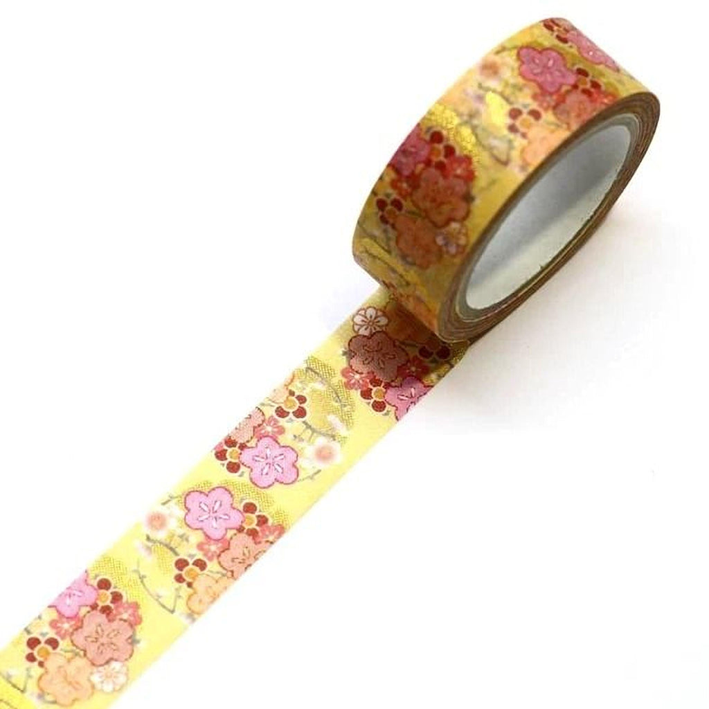 A roll of yellow floral patterned tape is lying on a white surface.