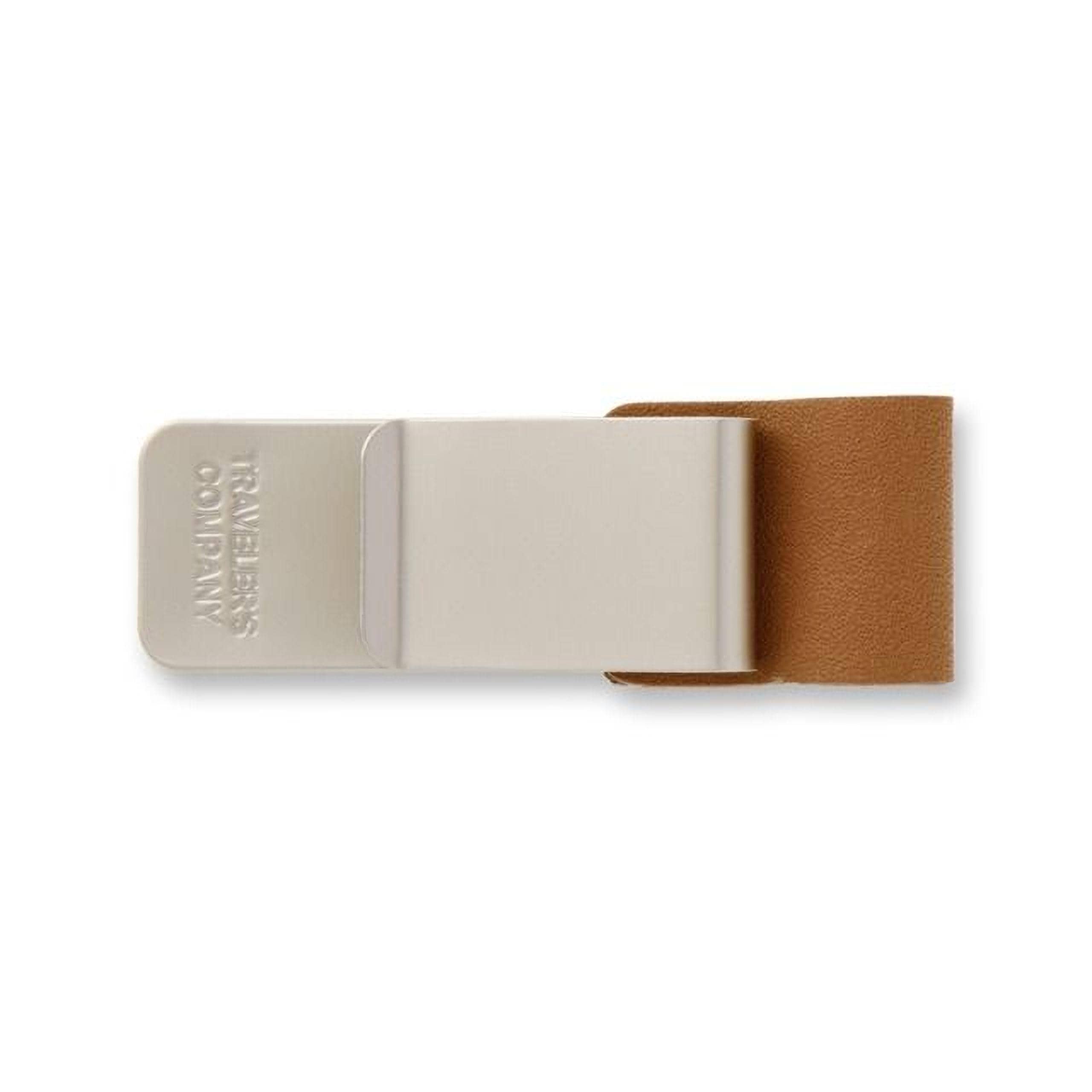A beige-colored metal clip with a brown leather cover attached to it.