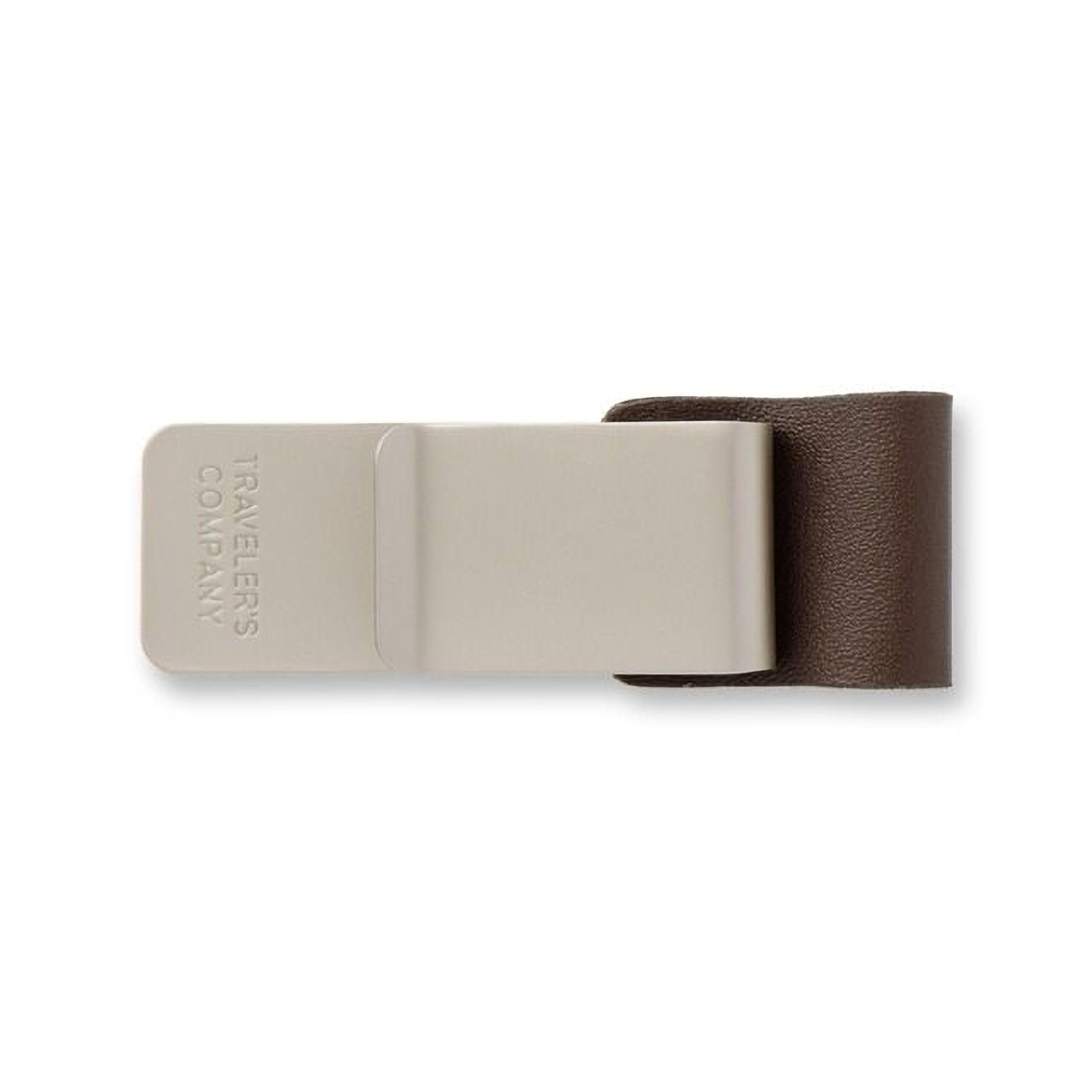 A beige-colored metal clip with the text "TRAVELERS COMPANY" printed on it.