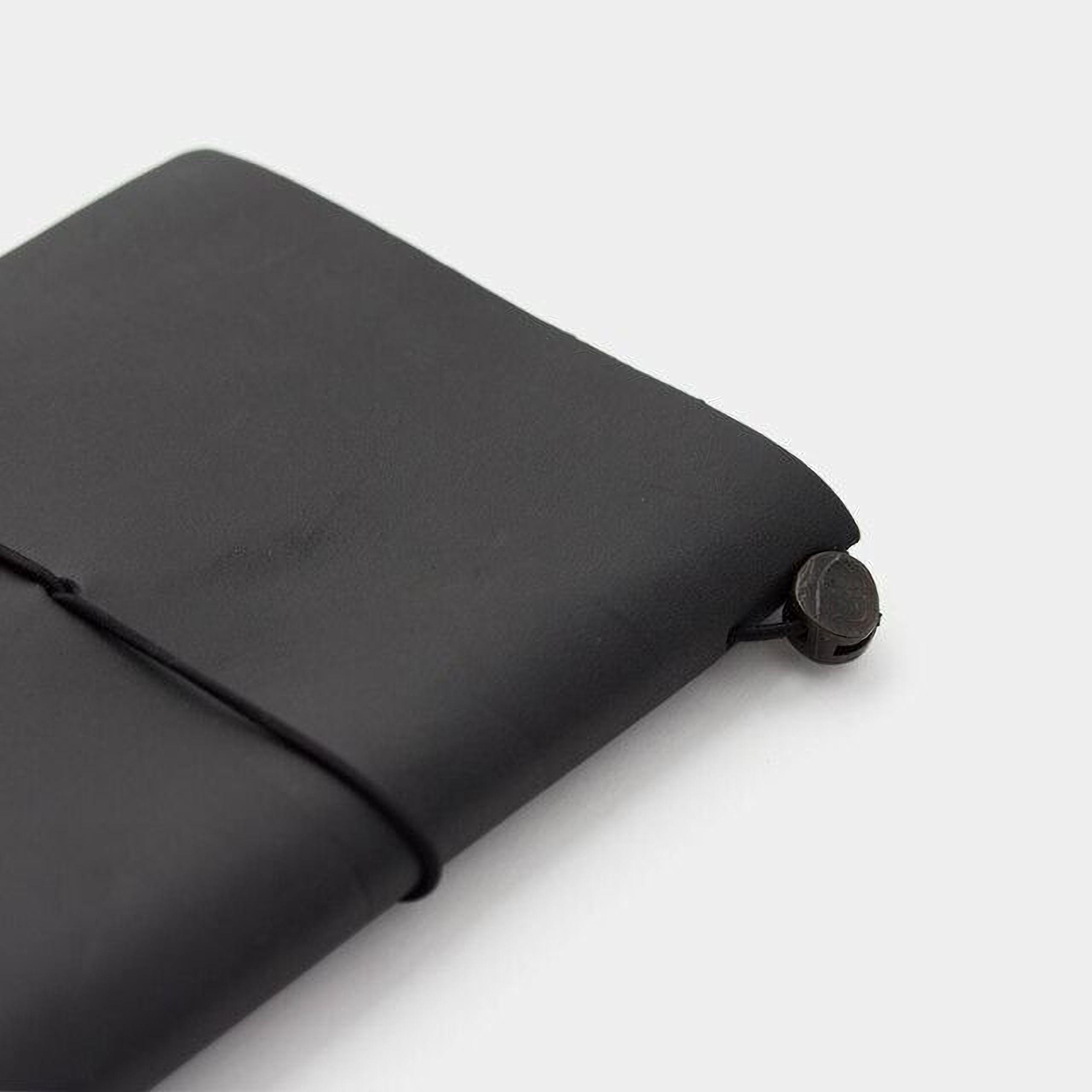 A black leather-bound notebook with a black strap and a metal clasp on the cover.