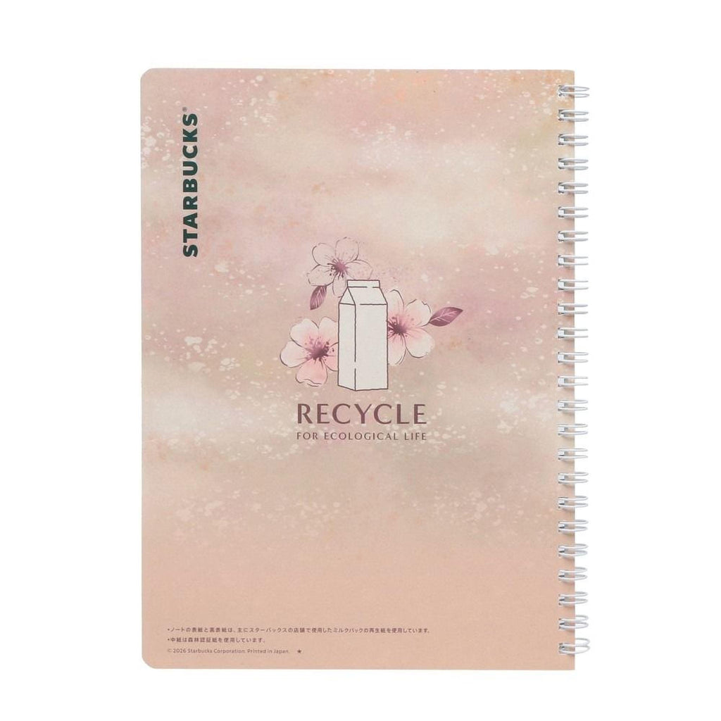 The image is a spiral notebook cover with a pink and white color scheme. It features a white milk carton with pink flowers and leaves, along with the text "RECYCLE for ecological life" printed on it.