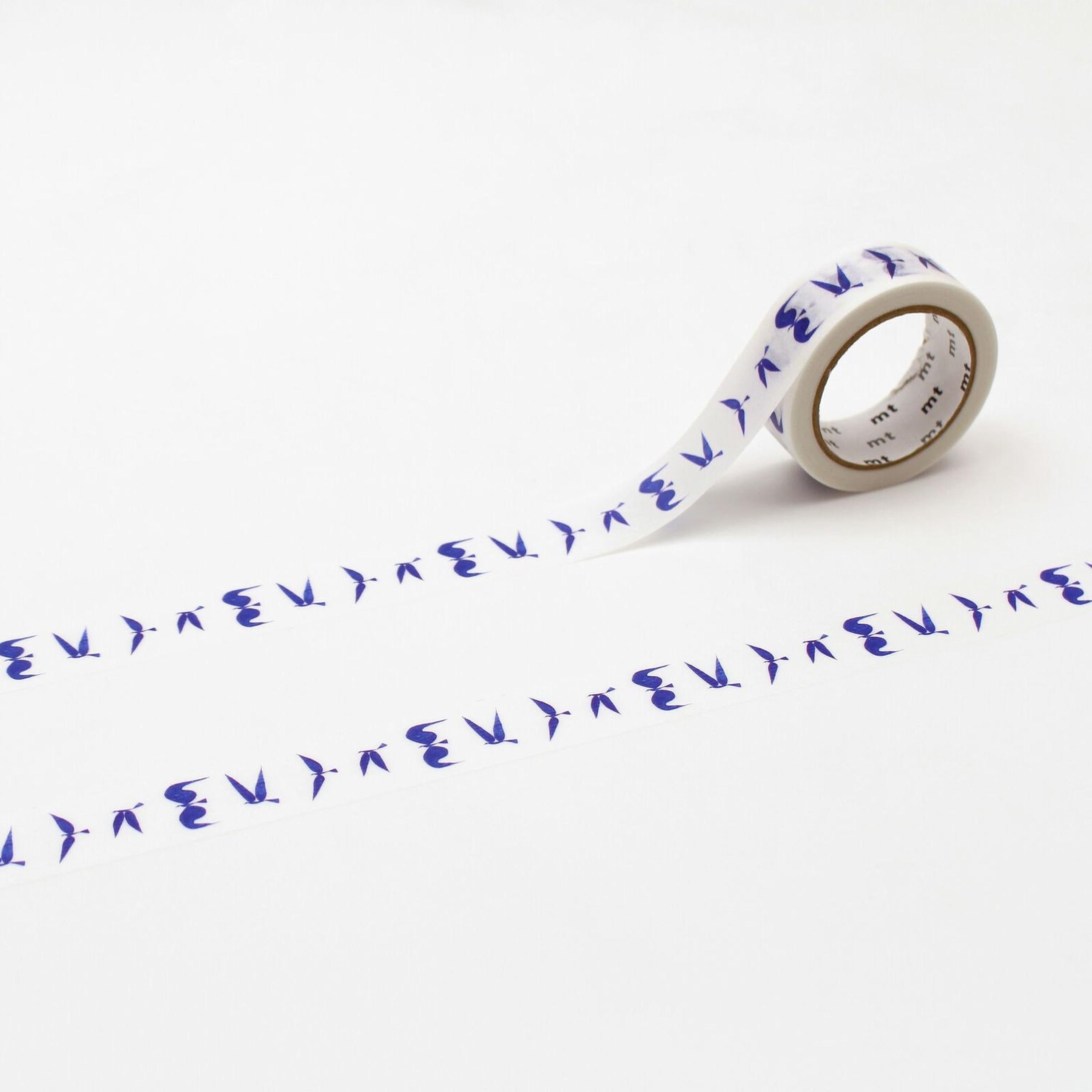 a roll of blue and white tape with a repeating pattern of blue birds on it, lying on a white surface.