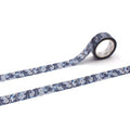 a roll of patterned tape with a blue and white floral design, lying on a white surface.