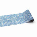 A roll of blue and white floral patterned paper is shown against a white background.