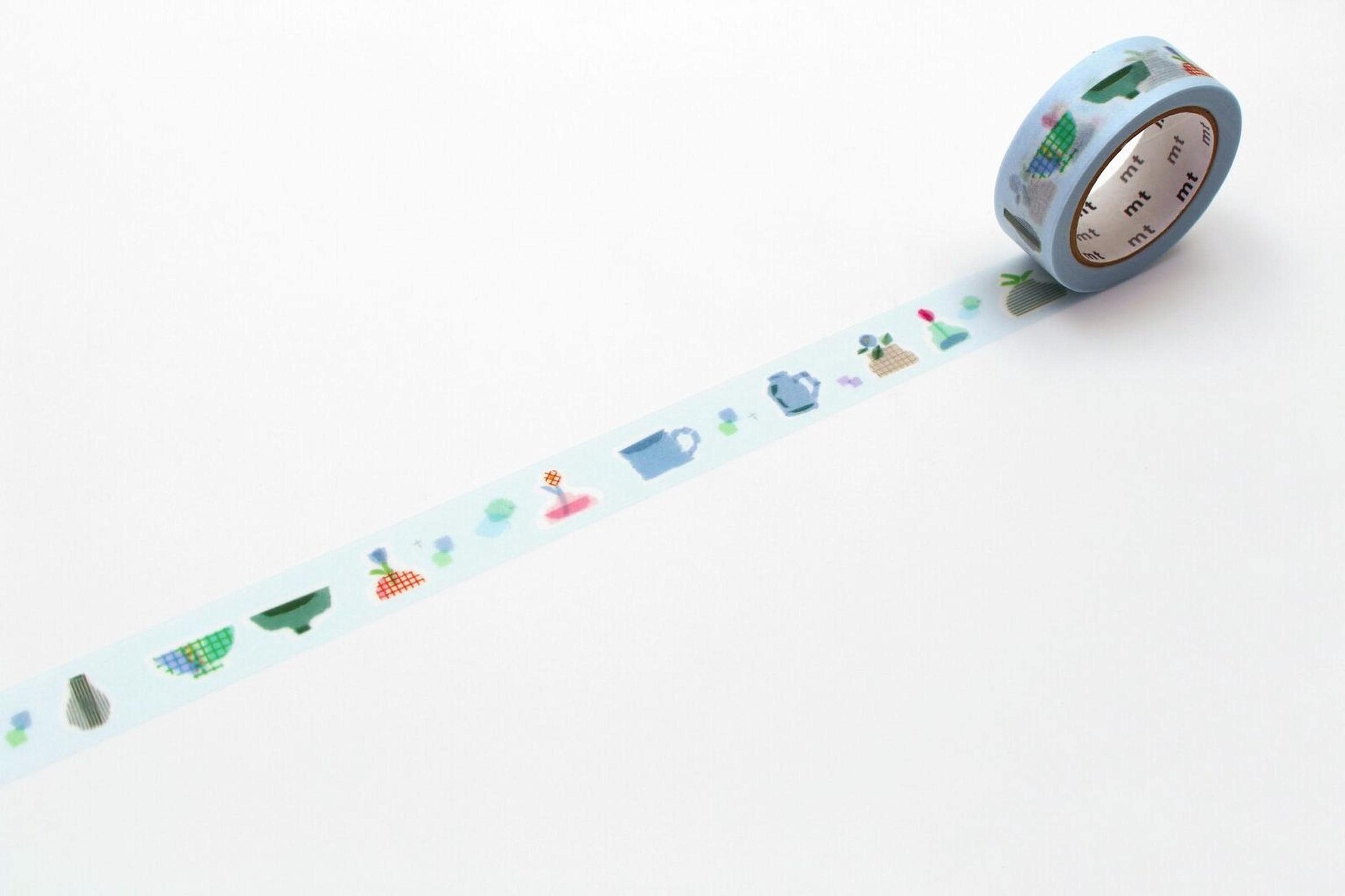 A roll of blue and white patterned tape with various objects such as a teapot, teacup, and teapot on it, along with a clock and a teapot, arranged in a row on a white background.