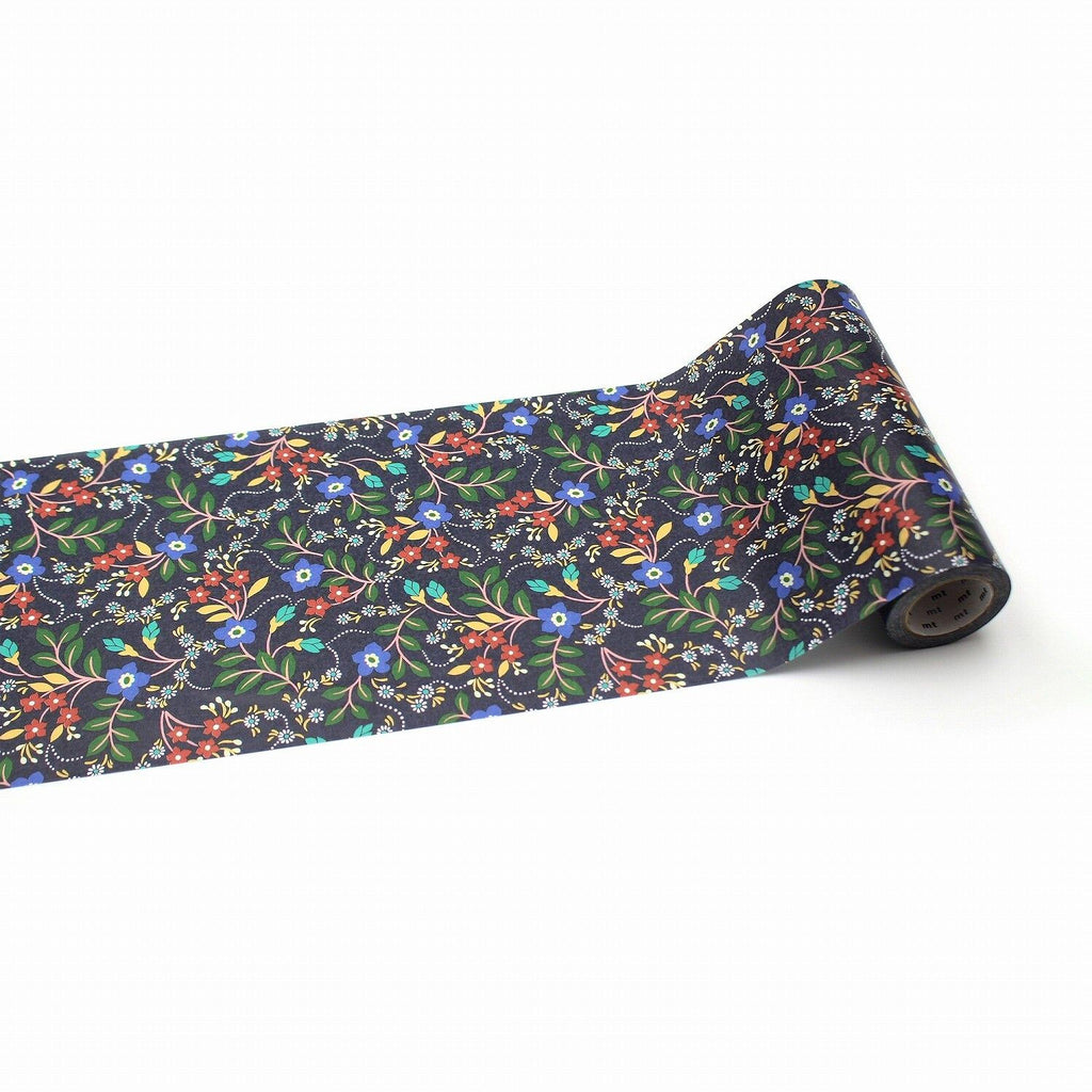 A roll of decorative paper with a floral pattern on it, lying on a white surface.