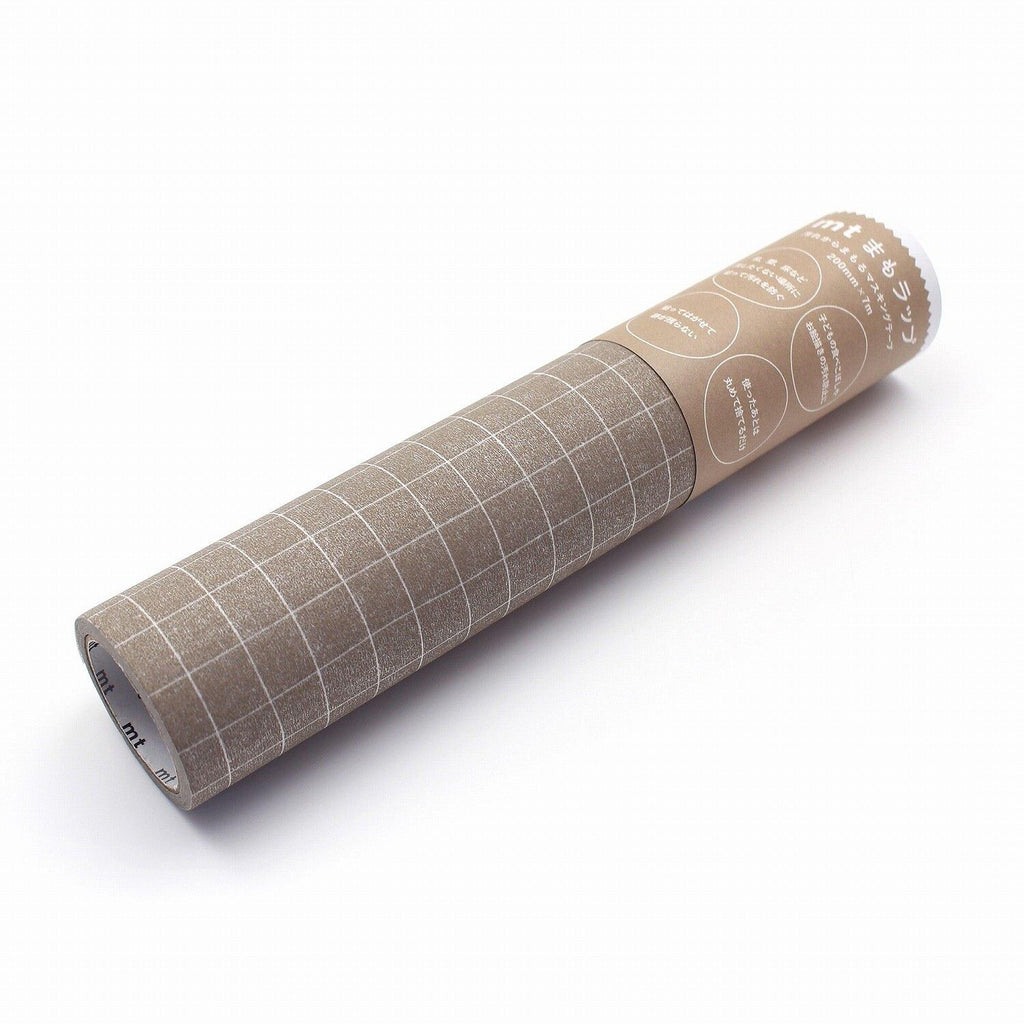 A roll of paper with a grid pattern on it, sitting on a white surface.