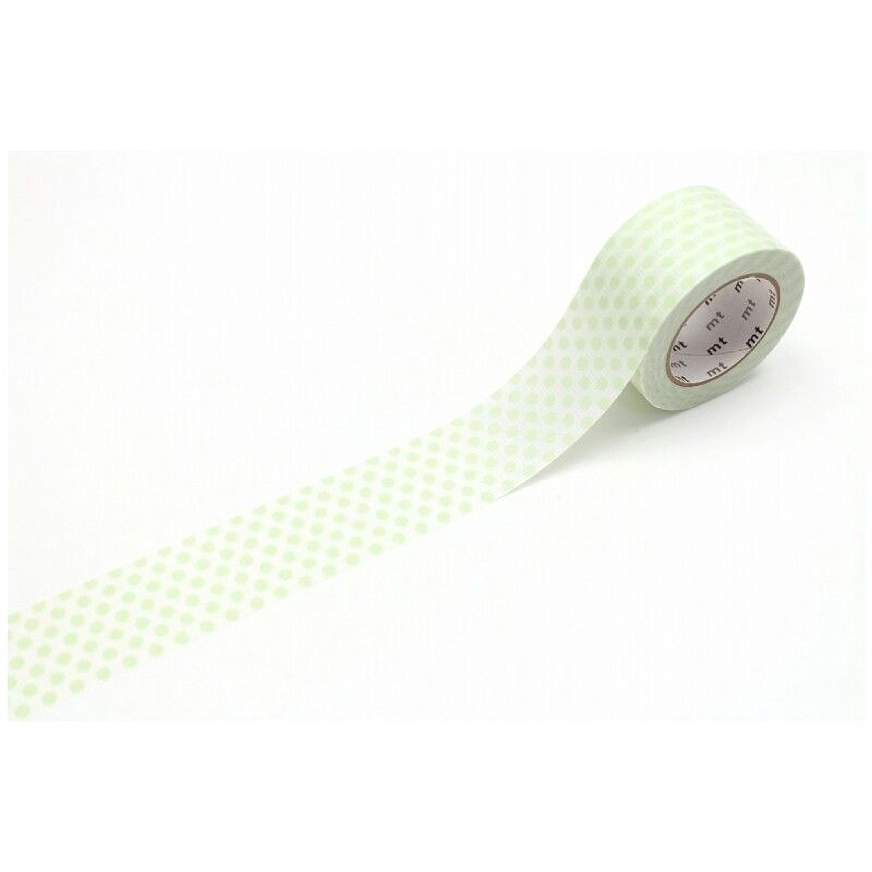 A roll of green and white polka dot tape is lying on a white surface.