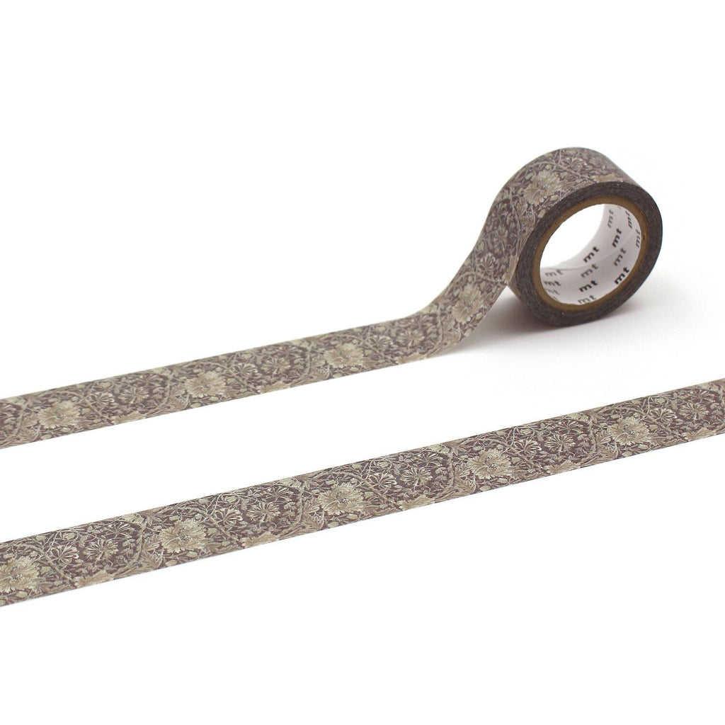 A roll of patterned tape with a floral design on it, lying on a white surface.