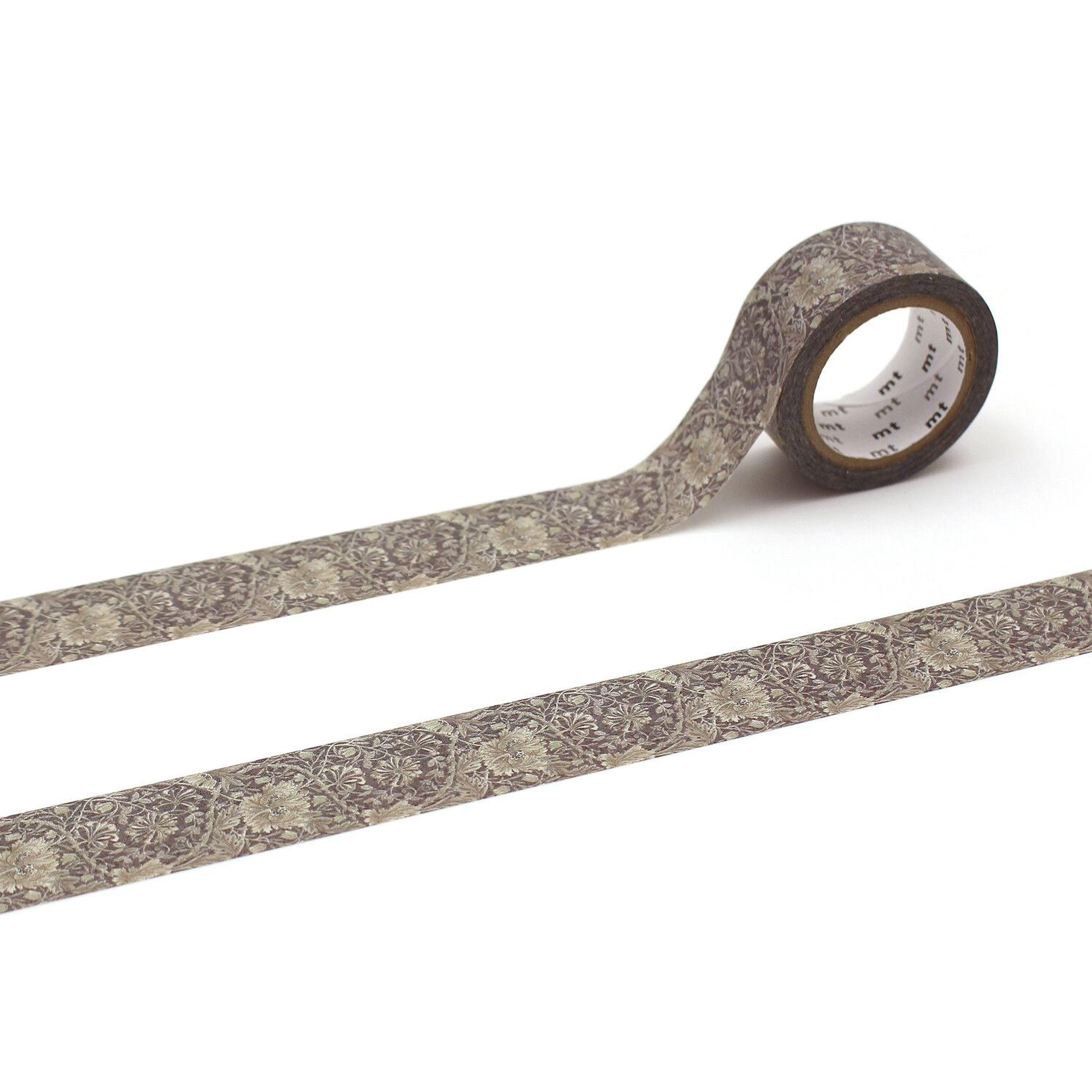 A roll of patterned tape with a floral design on it, lying on a white surface.