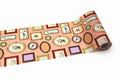 a roll of paper with a repeating pattern of various framed items, including pictures, clocks, and other decorative elements, all set against a peach-colored background.