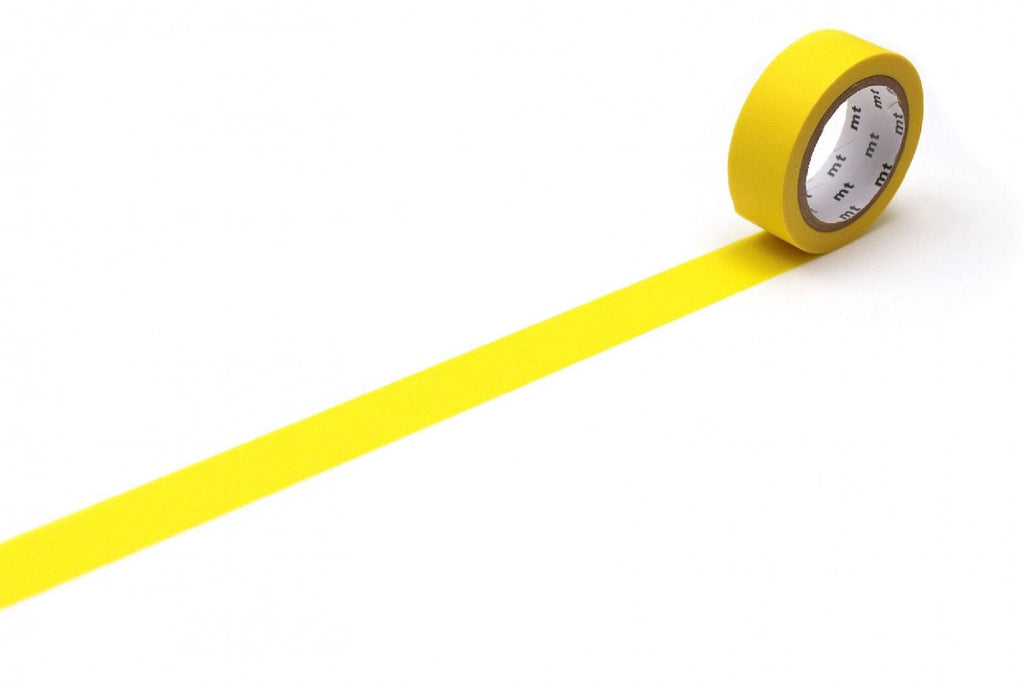 A yellow roll of tape is lying on a white surface, with a single yellow line extending from the tape.
