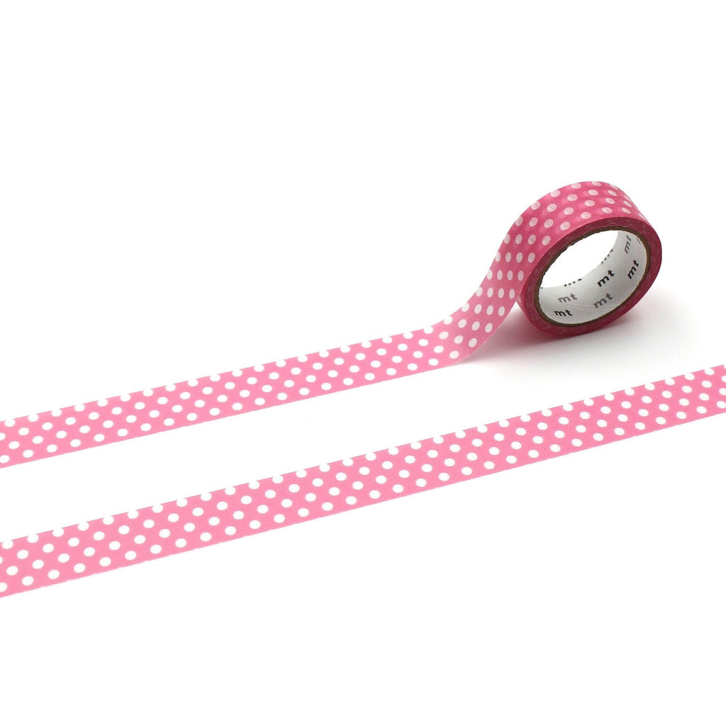 A roll of pink and white polka dot tape is lying on a white background.