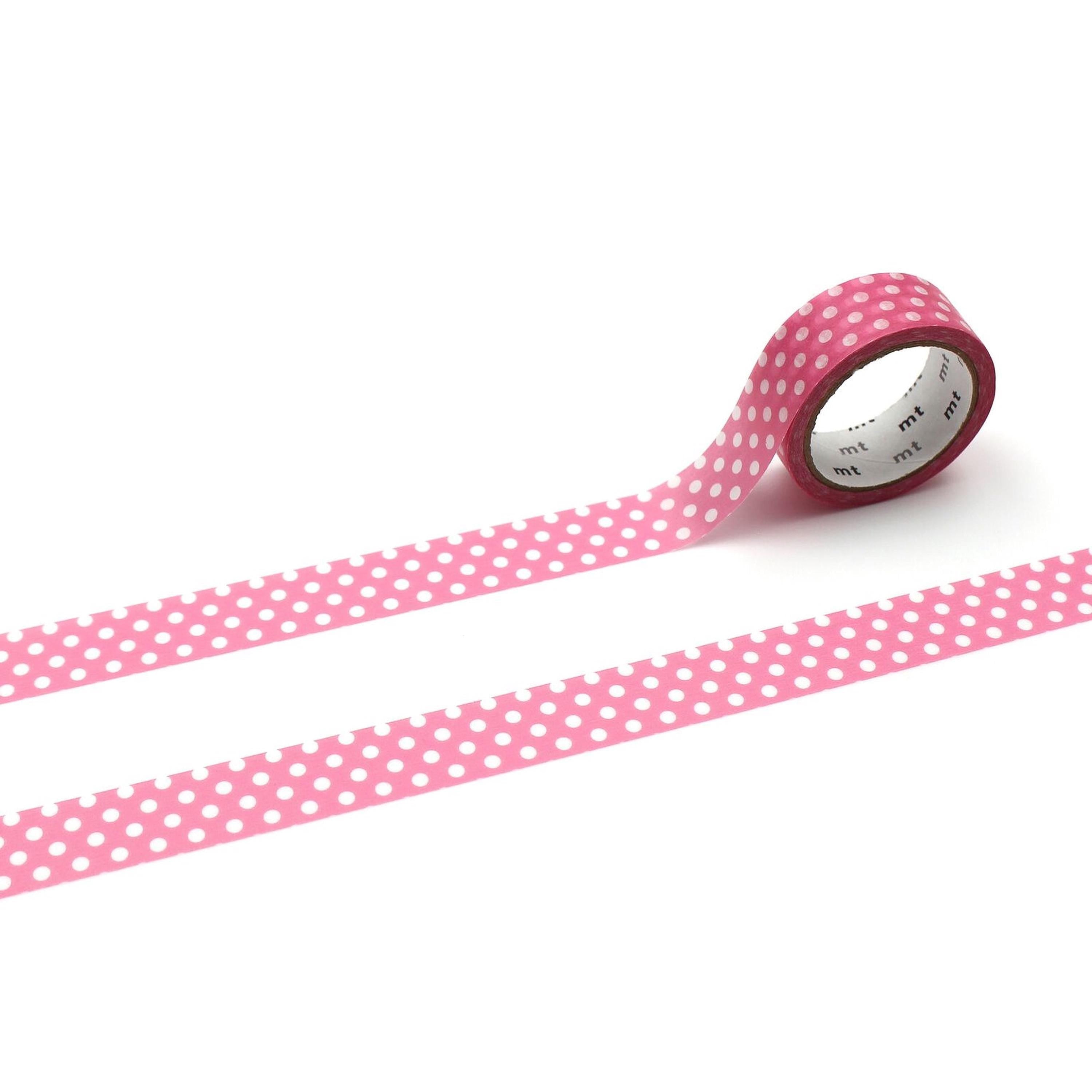 A roll of pink and white polka dot tape is lying on a white background.