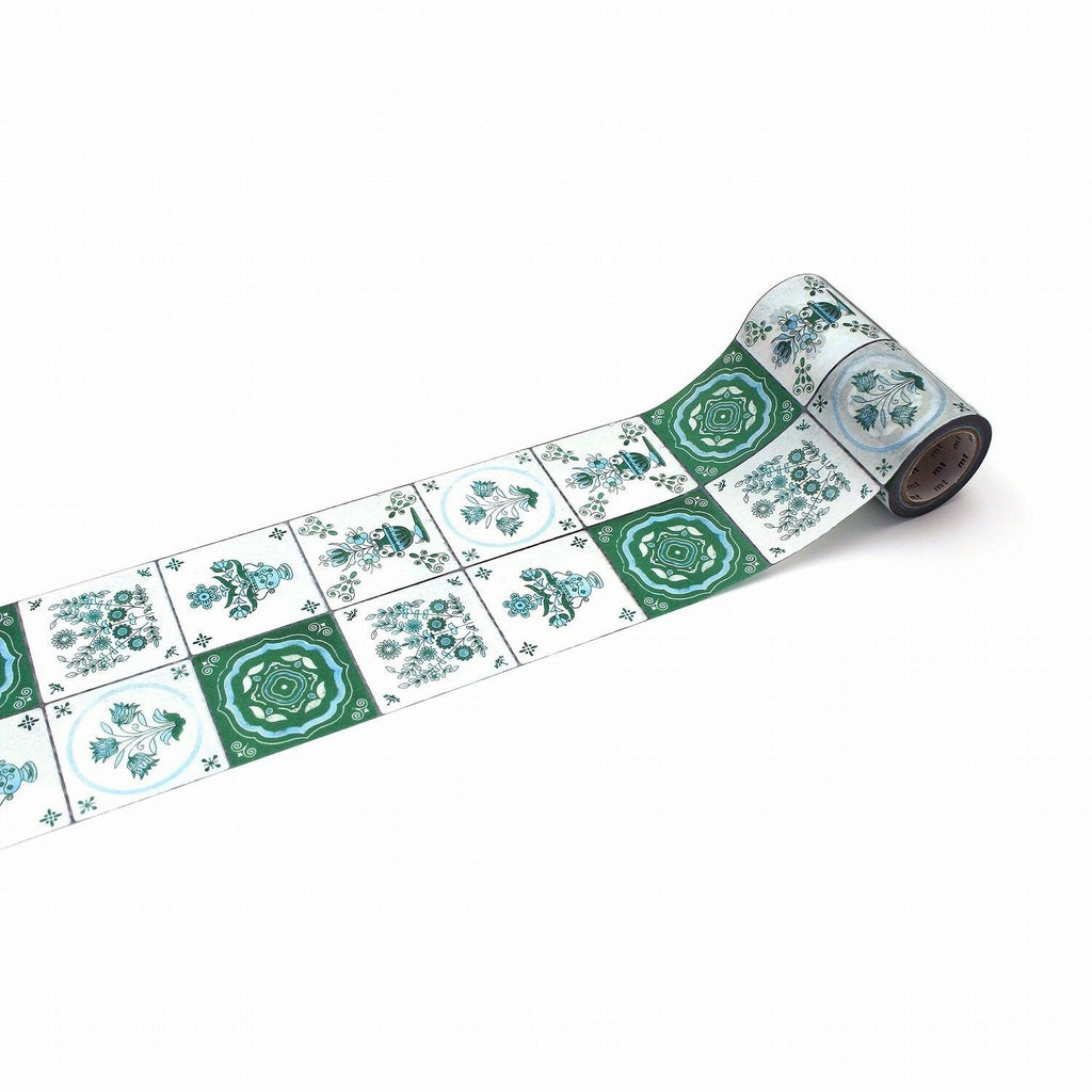 A roll of decorative paper with a repeating pattern of green and white tiles, featuring various floral and geometric designs.