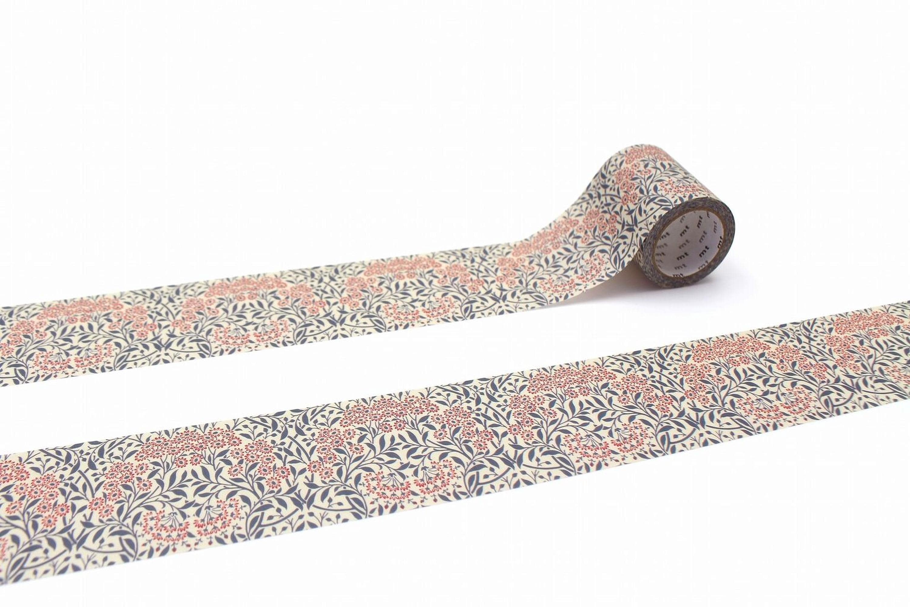 a roll of patterned tape with a floral design, lying on a white surface.