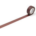 A roll of brown tape is lying on a white surface, with a single brown line extending from the tape.