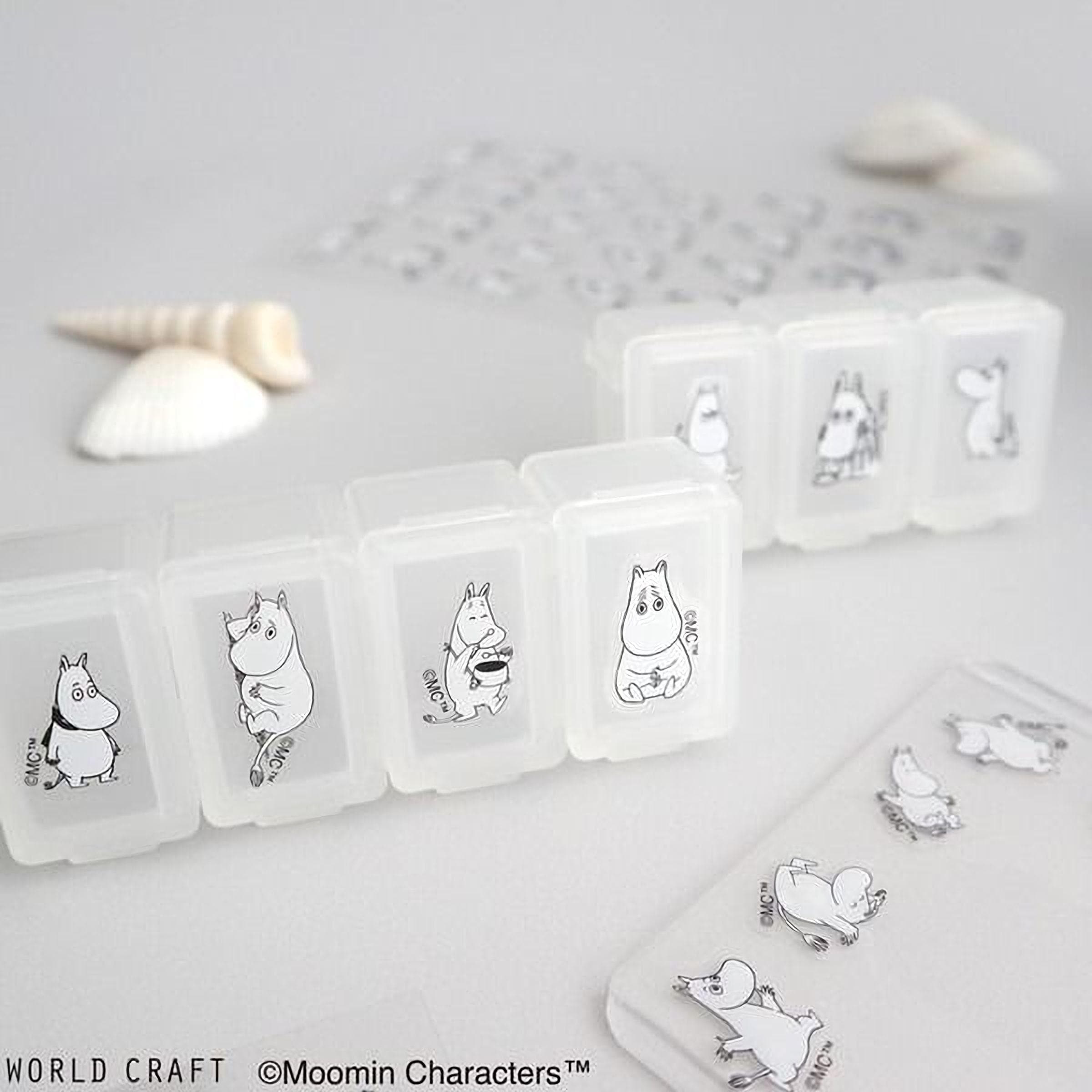 a collection of clear plastic containers with black and white illustrations of Moomin characters on them, along with some seashells and a small object.