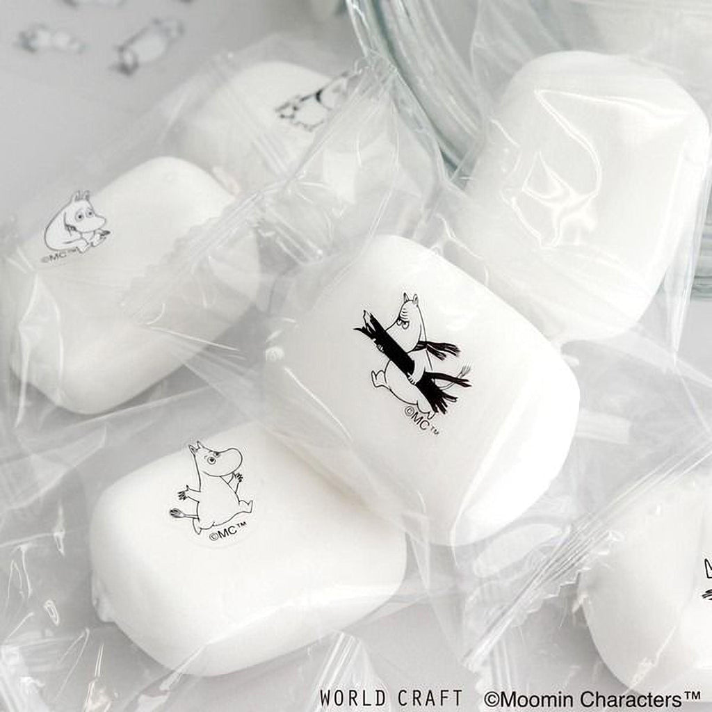 several white soap bars with black character designs on them, placed on a white surface.