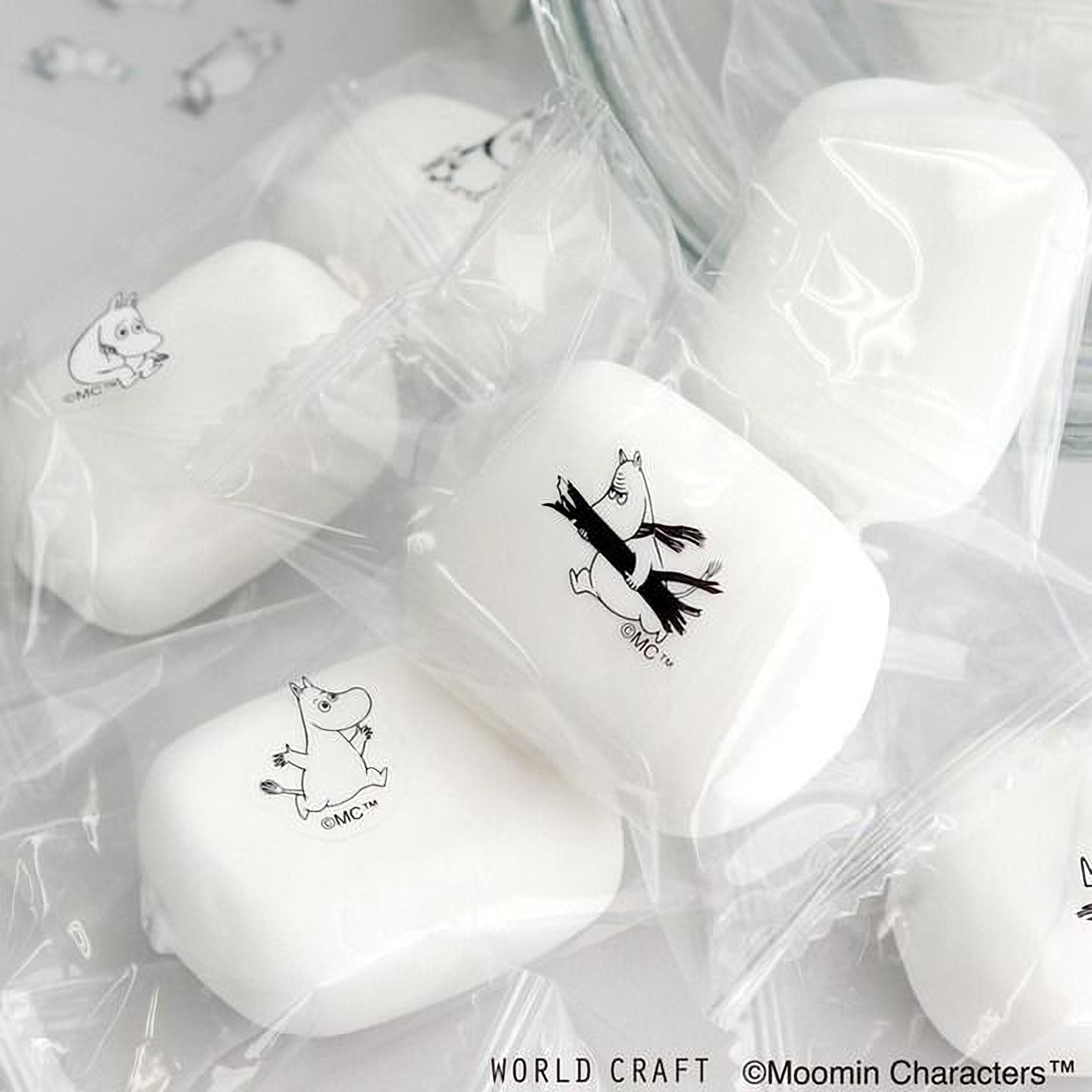 several white soap bars with black character designs on them, placed on a white surface.