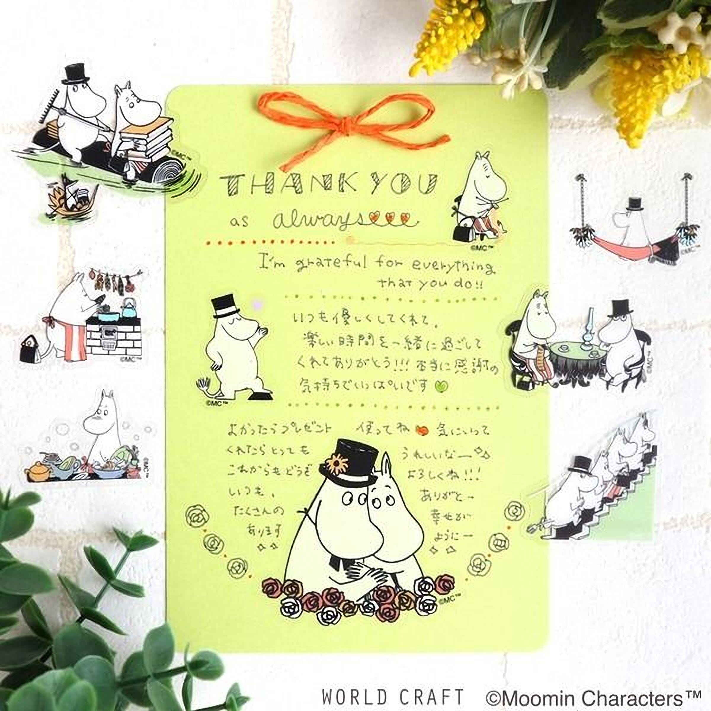 The image is a colorful card with illustrations of Moomin characters, a handwritten message expressing gratitude, and various other Moomin-themed stickers. The card is surrounded by yellow flowers and green plants, creating a cheerful and festive atmosphere.