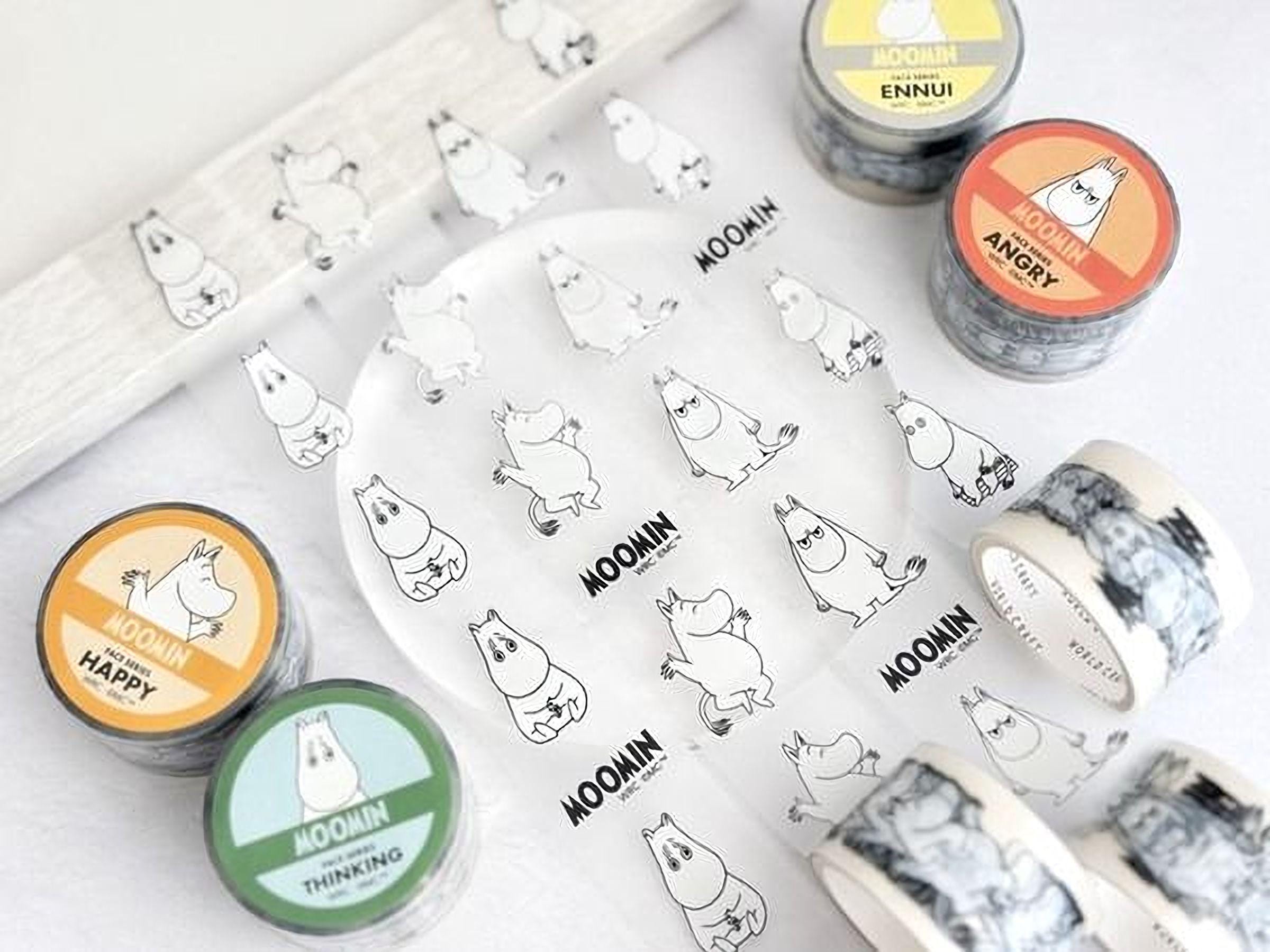 various Moomin products, including rolls of tape and stickers, arranged on a white surface.