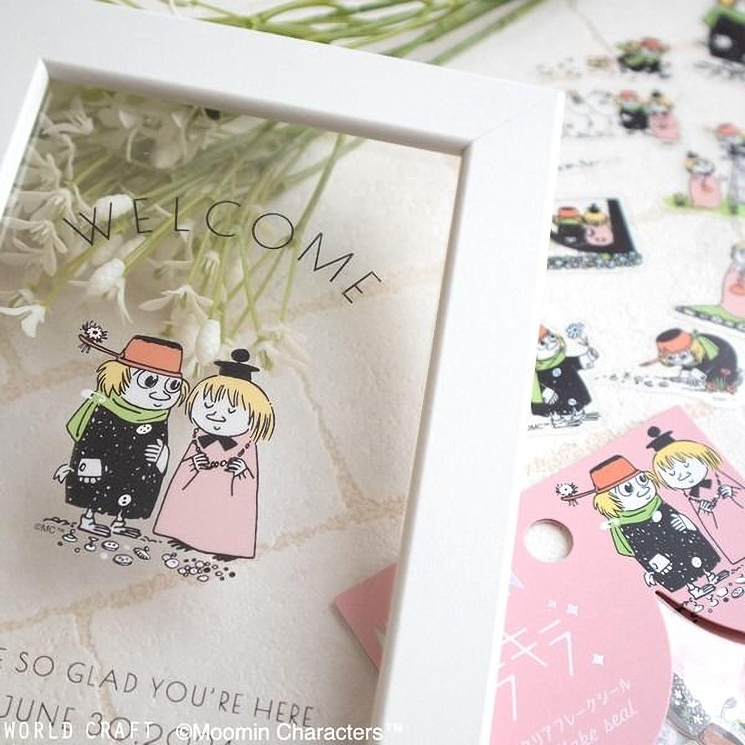 a white frame with a greeting card inside, surrounded by various stickers and illustrations.