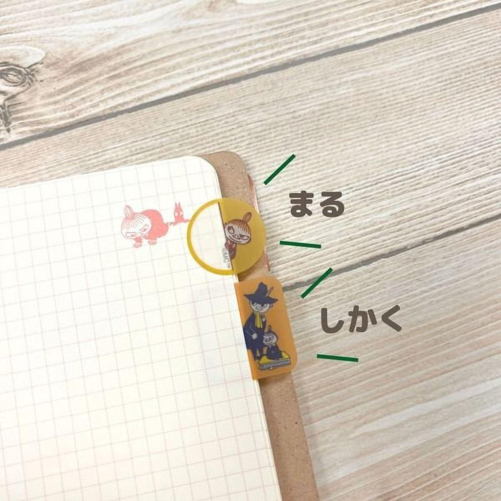 a notebook with a grid pattern, a yellow and orange bookmark, and some Japanese text.