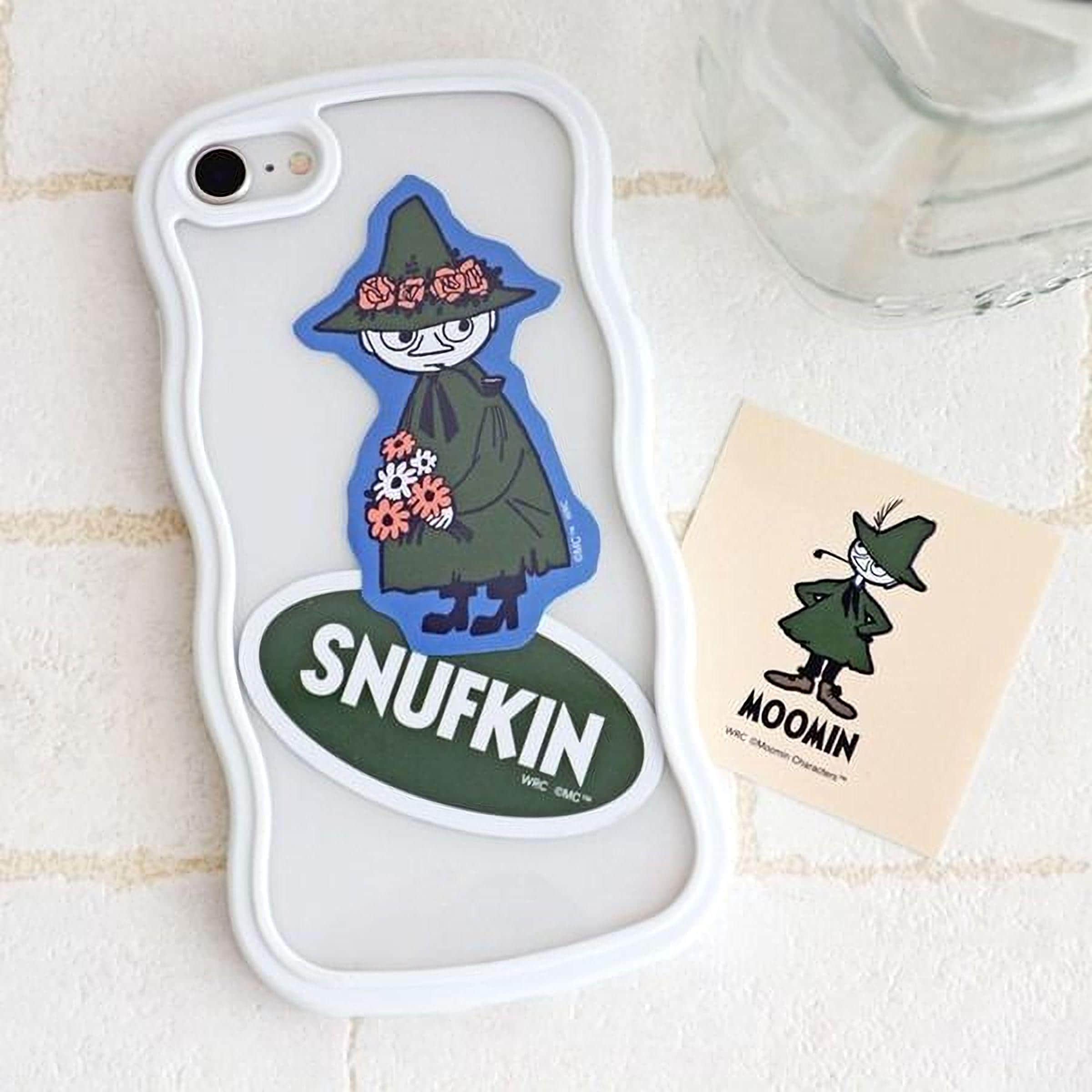 a white phone case with a sticker of Snufkin, a character from the Moomin cartoon series, and a small sticker of Moomin characters.