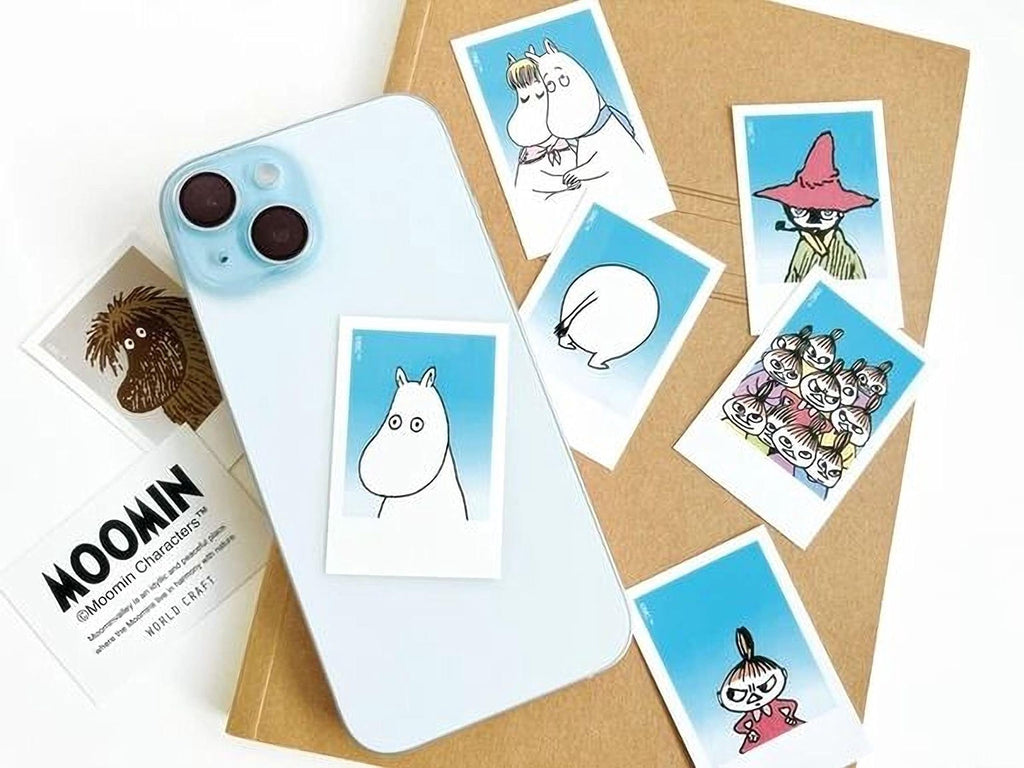 a smartphone with a sticker of a character from the Moomin cartoon series, along with several other stickers and a book.