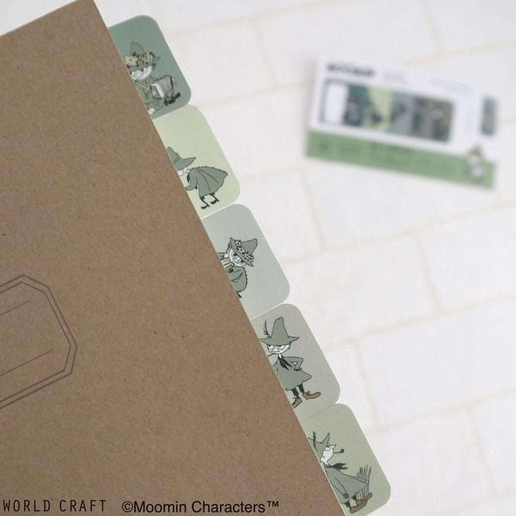 A brown folder with a series of green stickers featuring illustrations of characters from the Moomin character series, placed on a white surface.