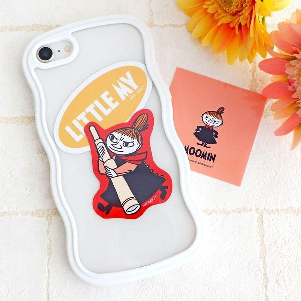 a white phone case with a cartoon character sticker, a pink card with a cartoon character, and some flowers on a white surface.