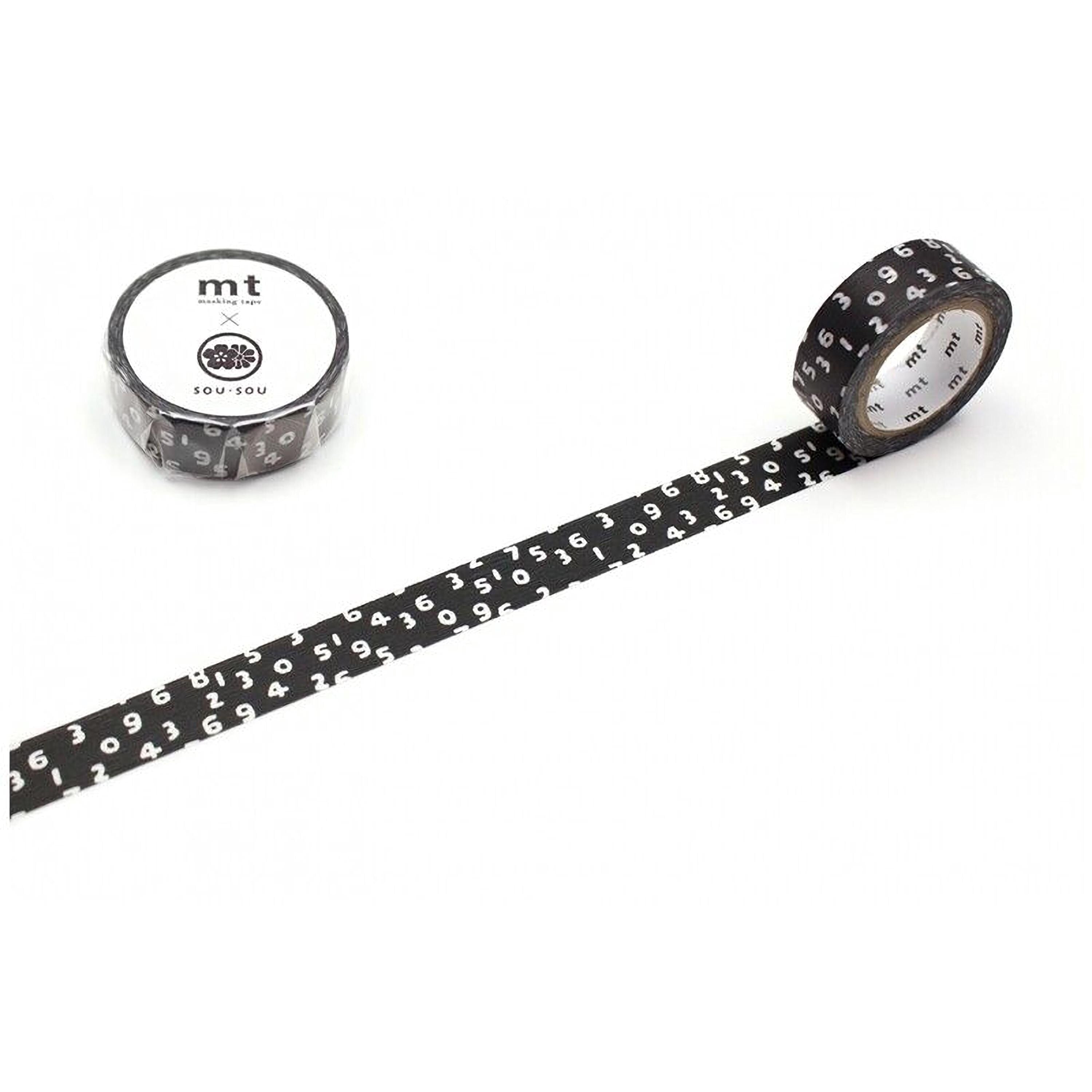 a roll of black and white patterned tape with numbers on it, lying on a white surface.
