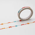 a roll of tape with a decorative pattern of red, orange, and blue bows on a white background.