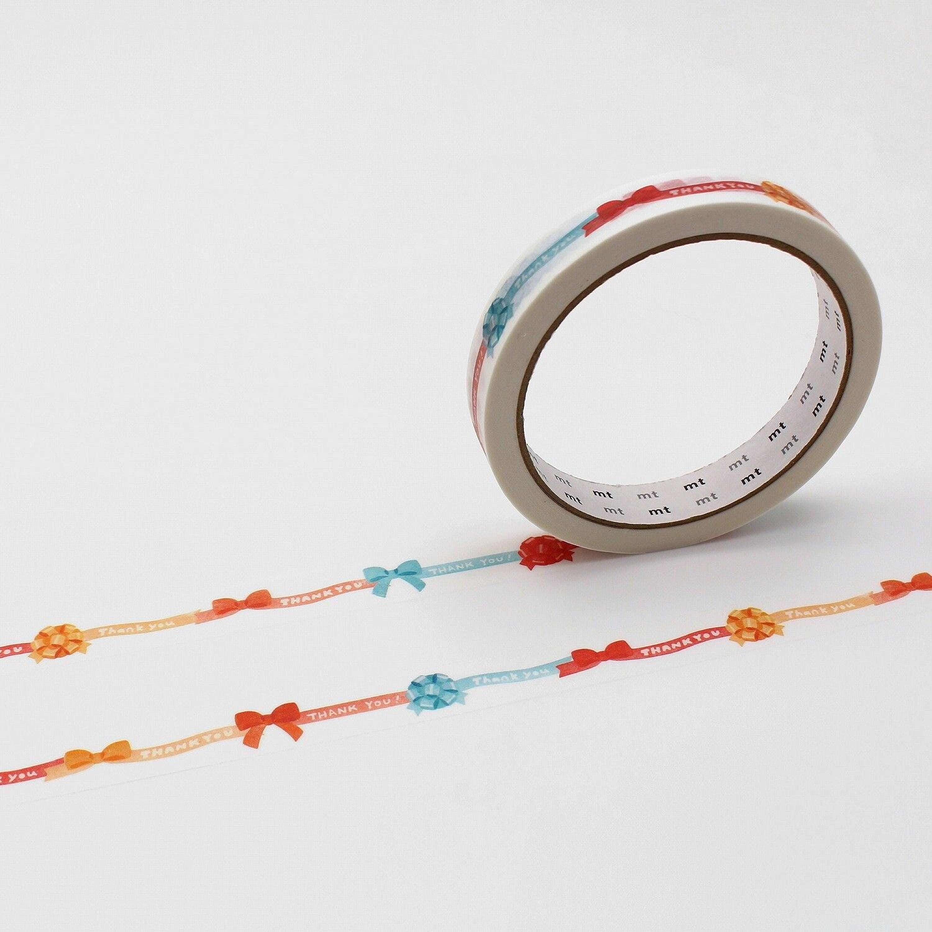 a roll of tape with a decorative pattern of red, orange, and blue bows on a white background.