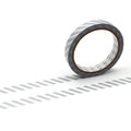 A roll of black and white striped tape is lying on a white surface, with a shadow cast by the tape.