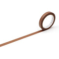 A roll of brown tape is lying on a white surface, with a long brown line extending from the tape.