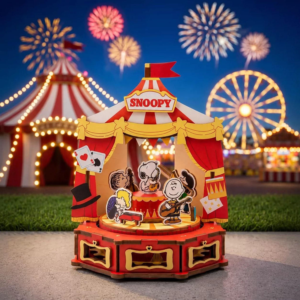 A miniature Peanuts-themed carnival ride with a circus tent and fireworks in the background.