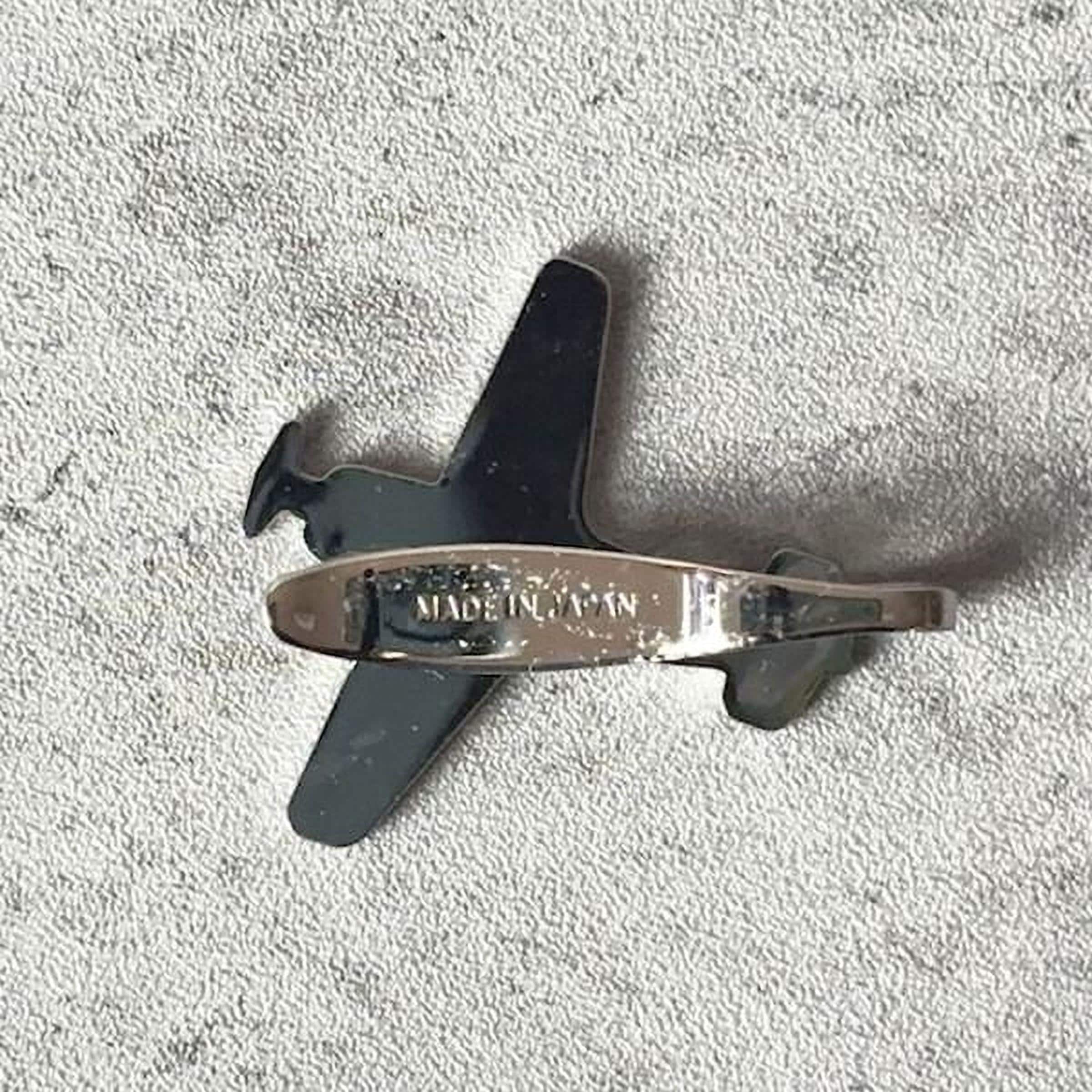 A metallic airplane-shaped object with the text "MADE IN JAPAN" printed on it.