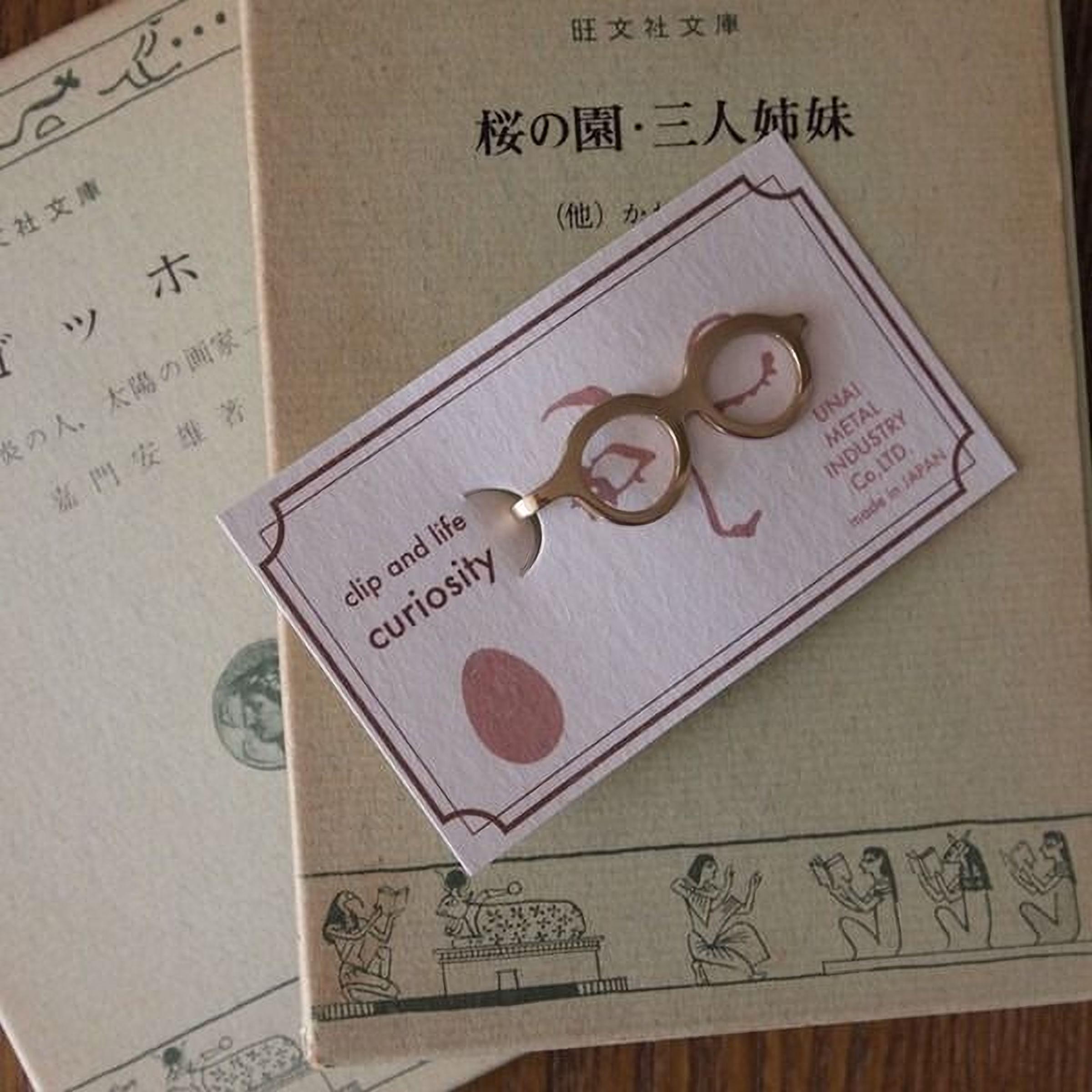 a pair of small, round glasses placed on top of a card with text and illustrations.